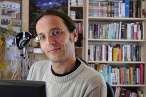 A photo of Andrew in front of his famous bookcase. (68kB)